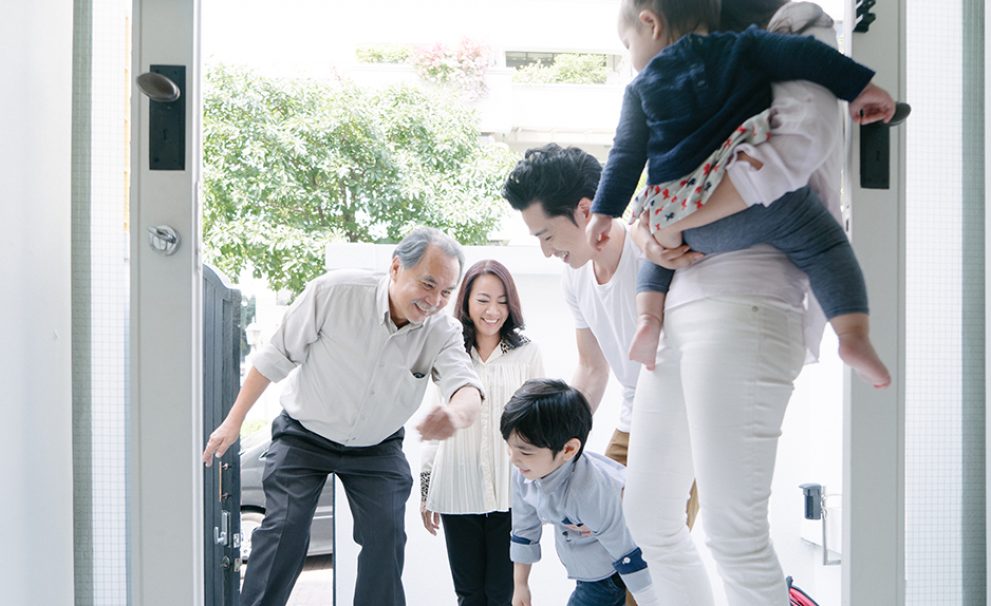 Young family welcoming grandparents at home